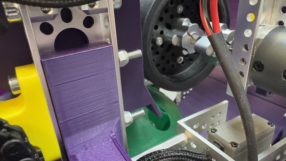 Close-up of custom 3D-printed purple robot structural components made by students.